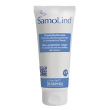 A white tube Dr. Schnell SAMOLIND skin protection by DR.SCHNELL GmbH & Co. KGaA with blue accents and German/English text. The cream protects stressed skin from moisture and contains Vitamin E.