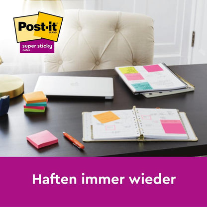 On a desk with notebooks, a pen, and a closed laptop, several Post-it® Super Sticky Notes (47.6 mm x 47.6 mm, 90 sheets/block, 100% PEFC) from 3M Deutschland GmbH are attached to the notebooks. The text below reads: "Stick again and again."