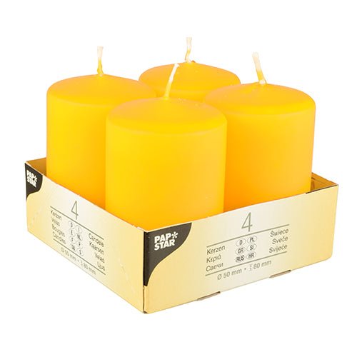 Four Starpak pillar candles "Ivory" (Ø 50 mm, 80 mm, flat top) are arranged in a cardboard holder with the inscription "Starpak". The multilingual packaging highlights the quality of the wax and clearly indicates that the pack contains four candles.