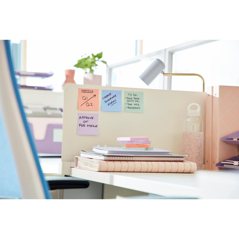 On a modern office desk, the Post-it® Super Sticky Notes (47.6 mm x 47.6 mm, 90 sheets/block, 100% PEFC) from 3M Deutschland GmbH are on a partition with note papers. Natural light from large windows illuminates the workspace.