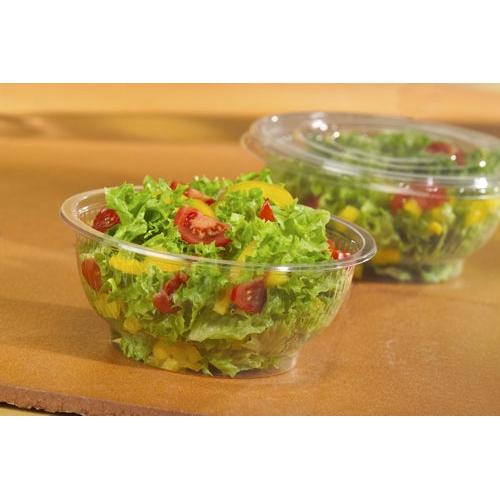 In the front, there is a round, crystal clear Starpak 50 salad bowl R-PET with mixed salad, cherry tomatoes, and yellow peppers, in the background another eco-friendly Starpak salad bowl – both with transparent plastic lids.