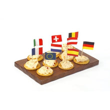 A wooden tray contains seven crackers, each with a spread and topped with PAPSTAR decoration picks 8 cm "Nations" (various countries & EU). Perfect as table decoration for celebrations and events. Brand: PAPSTAR GmbH.