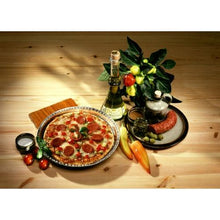 A pepperoni pizza is served on a plate alongside wine, salami, olives, and fresh ingredients. Expertly baked in Starpak 25 round pans—round aluminum pans from Starpak designed for optimal heat conduction—on a rustic wooden table.