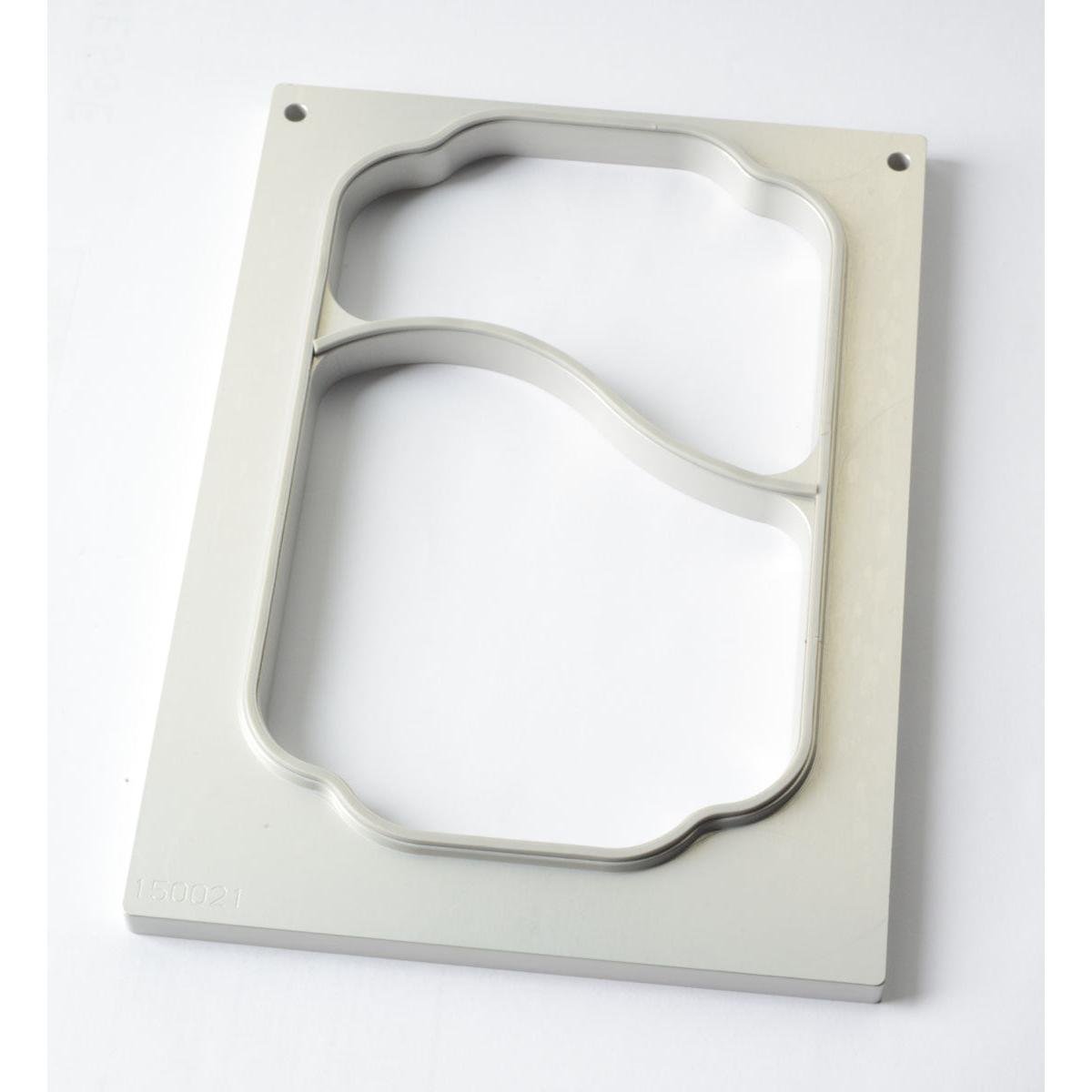 A rectangular cassette DF10/20 for PP trays, 700/400 ml, 2-compartment by Duni GmbH, with two irregularly shaped cutouts and a thin metal bridge, lies on a white surface.