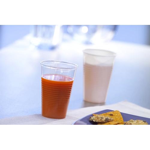 A Starpak 100 drinking cup, PP, white, filled with orange juice, stands in front of a white cup with a light pink drink. In the foreground, a blue plate with crackers is visible - ideal for events.