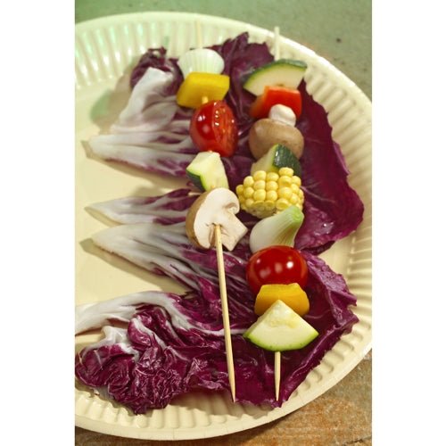 Two vegetable skewers on PAPSTAR 250 bamboo skewers, "pure" by PAPSTAR GmbH – made from eco-friendly, biodegradable bamboo – with mushrooms, cherry tomatoes, corn, zucchini, onions, bell peppers on a paper plate with radicchio.