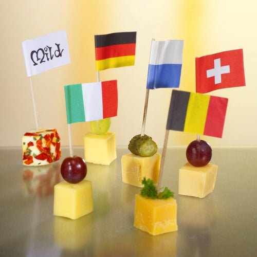 Present six cheese cubes, each with a PAPSTAR 500 Deco-Picker (8 cm, white) from PAPSTAR GmbH – German, French, Swiss, Italian, Belgian, and "mild" flags – garnished with grapes, gherkins, or herbs for an elegant presentation.