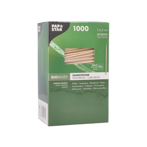 The green-white box of PAPSTAR GmbH toothpicks round 6.5 cm, wood with menthol flavor, dispenser box with 1000 pieces is labeled in multiple languages and has a window through which the wooden toothpicks with menthol flavor can be seen.