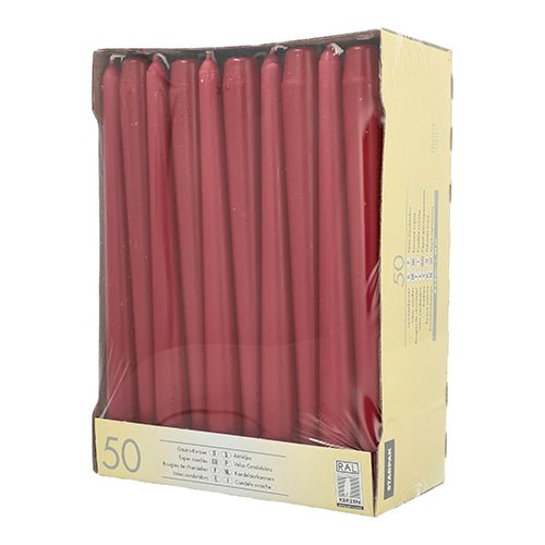 A beige box with 50 Starpak taper candles (Ø 2.2 cm, 25 cm) is visible through a clear plastic packaging, with texts and symbols printed on the lower left and right.