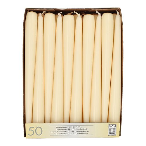 A box labeled "Starpak 50 taper candles Ø 2.2 cm - 25 cm" contains 50 upright white candles in two rows. The front of the box features multilingual text and the number 50.