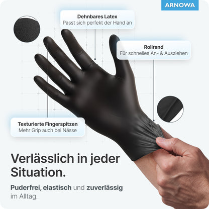 A person is wearing ARNOMED LATEX BLACK powder-free disposable gloves made of black latex from ARNOWA GmbH, with stretchable latex, textured fingertips for grip, and rolled cuff—all product information in German.