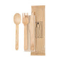 The Duni GmbH 4/1 cutlery set made of naturally waxed wood contains a fork, knife, spoon, and brown napkin (160/165/160), hygienically packed in 250 pieces - environmentally friendly on a white background next to an illustrated paper bag.