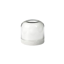 Under a clear glass dome with a flat bottom sits a stack of white, round objects resembling the LED candle holder made of plastic Stella by Duni GmbH - decorative and durable. The background is solid white. The package contains 1 piece.