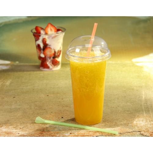 A Starpak 50 drinking cup "Hurricane", PET crystal-clear, with a domed lid and straw holds an orange slush. In the background, there is another Starpak To-Go cup with strawberries and cream, next to a green stirrer.