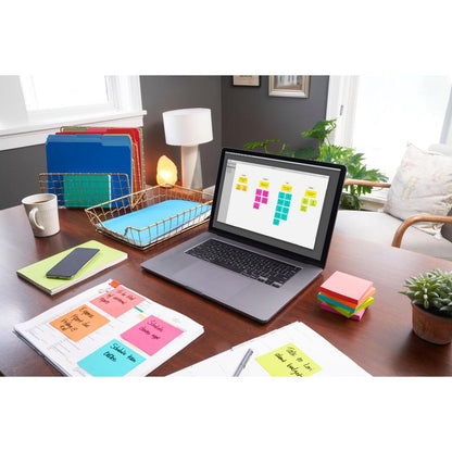 A tidy home office desk with a laptop and digital calendar, colorful folders, smartphone, notebooks, 3M Deutschland GmbH Post-it® Notes Poptimistic Collection (38 mm x 51 mm), pen, small plant, and lamp in bright daylight.