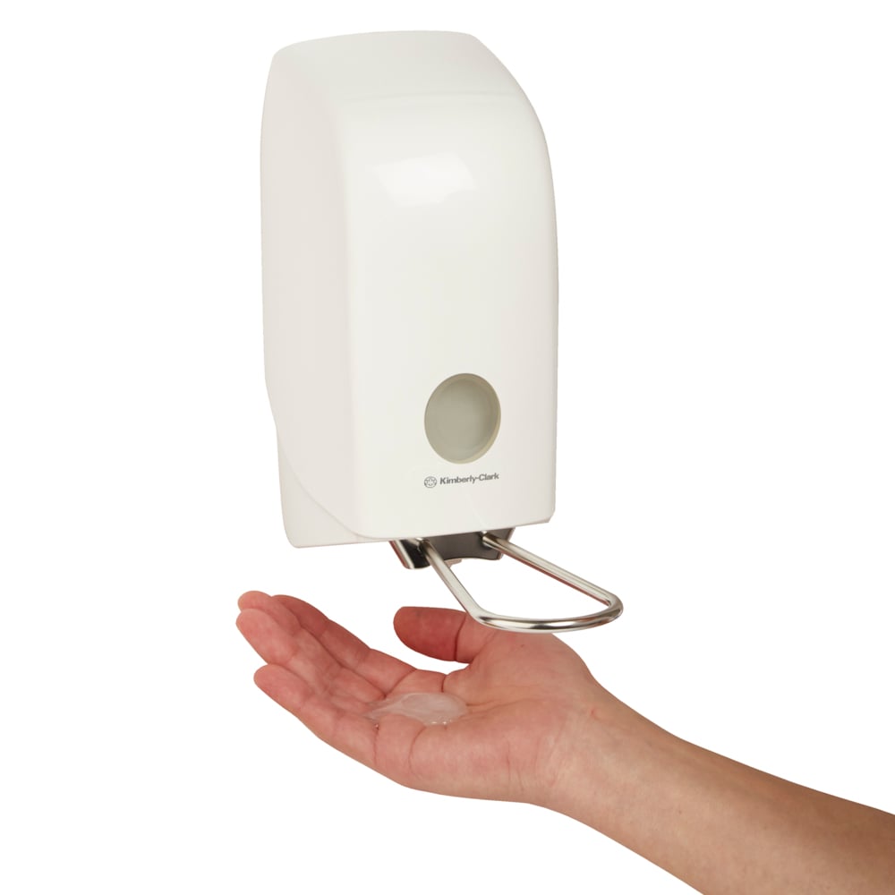 A hand is held beneath the wall-mounted Aquarius™ hand wash dispenser (white, 1 Ltr) from Kimberly-Clark GmbH, which dispenses the liquid onto the palm for easy and hygienic use.