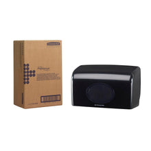 A cardboard box labeled "Aquarius" stands next to a black Kimberly-Clark GmbH Aquarius™ toilet paper dispenser (small rolls, 18.00 x 29.80 x 12.80 cm) with a transparent oval window, both on a solid white background.