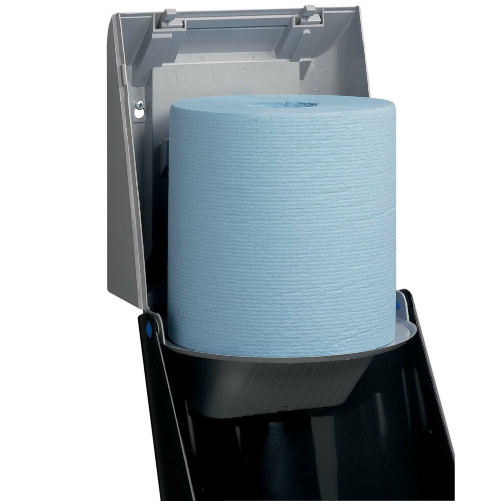 A close-up of a Kimberly-Clark Professional™ wiper dispenser - central pull / gray shows the open dispenser with a large blue roll, allowing for hygienic towel removal. By Kimberly-Clark GmbH.