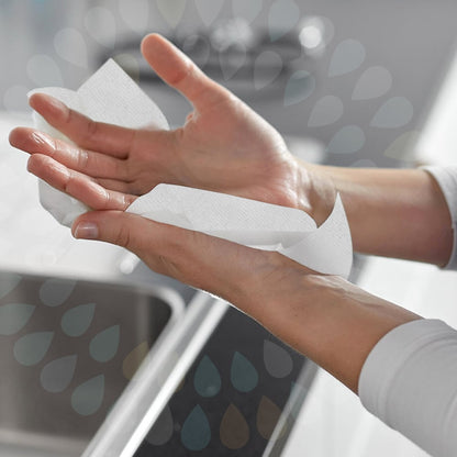 A person is drying their hands over a sink using Kleenex® Folded Hand Towels—White/Large (15 clips x 124 sheets | carton) by Kimberly-Clark GmbH, with both hands and part of the sink visible in the background.