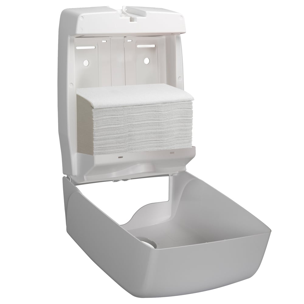 A white wall dispenser is open and shows a stack of Hostess™ NATURA™ hand towels - zig-zag fold, small (23 x 25 cm) from Kimberly-Clark GmbH. The lid is flipped up, the lower compartment remains empty.