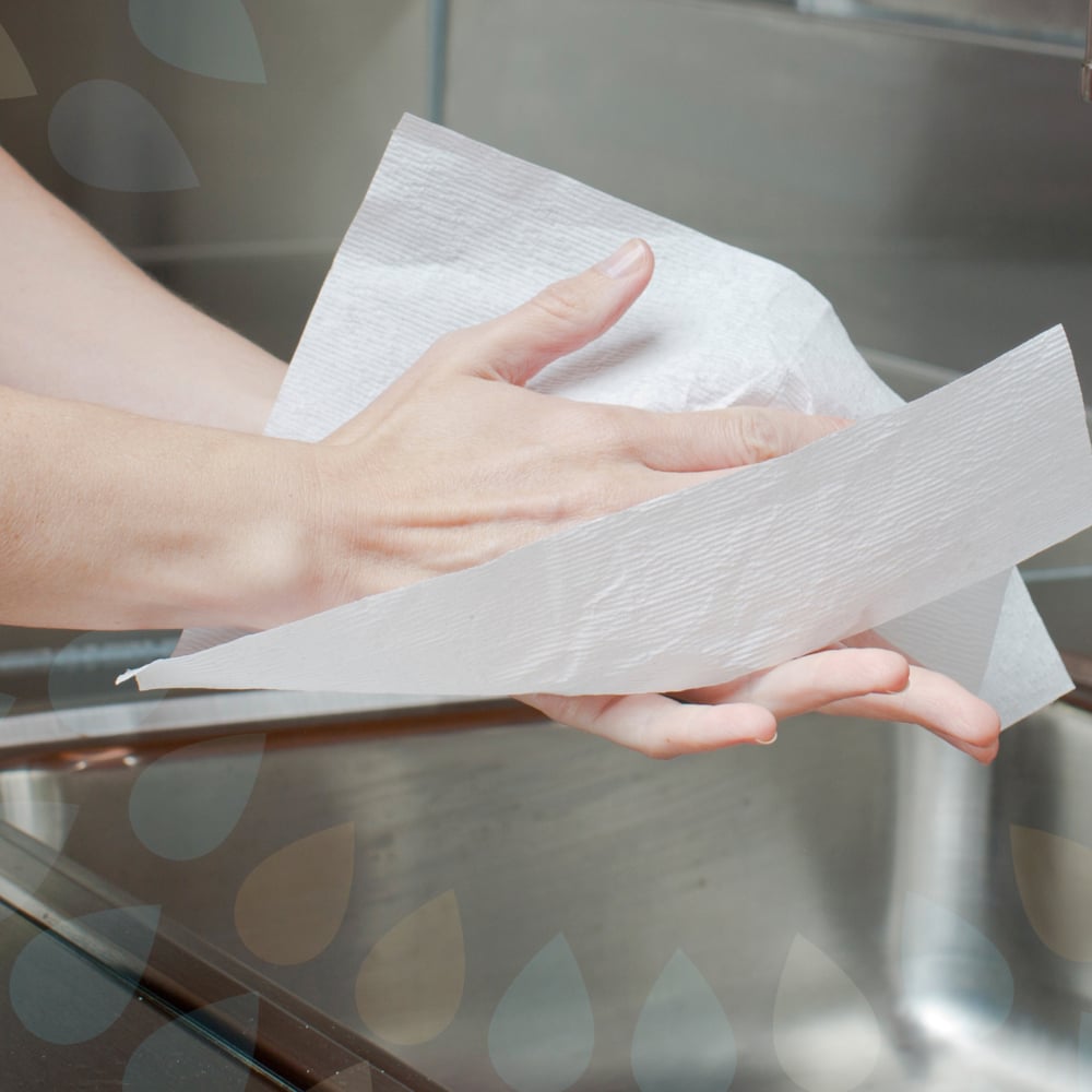 Someone dries their hygienic hands with Kleenex® Ultra™ Interfold Hand Towels - White, Medium (70 pieces, Kimberly-Clark GmbH) over a sink, with part of the faucet visible in the background.