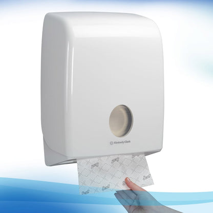 A white, wall-mounted dispenser by Kimberly-Clark GmbH dispenses a single sheet of Scott® Hand Towels - Narrow-Fold / White through the metallic front opening, ensuring hygienic hand drying with each pull.