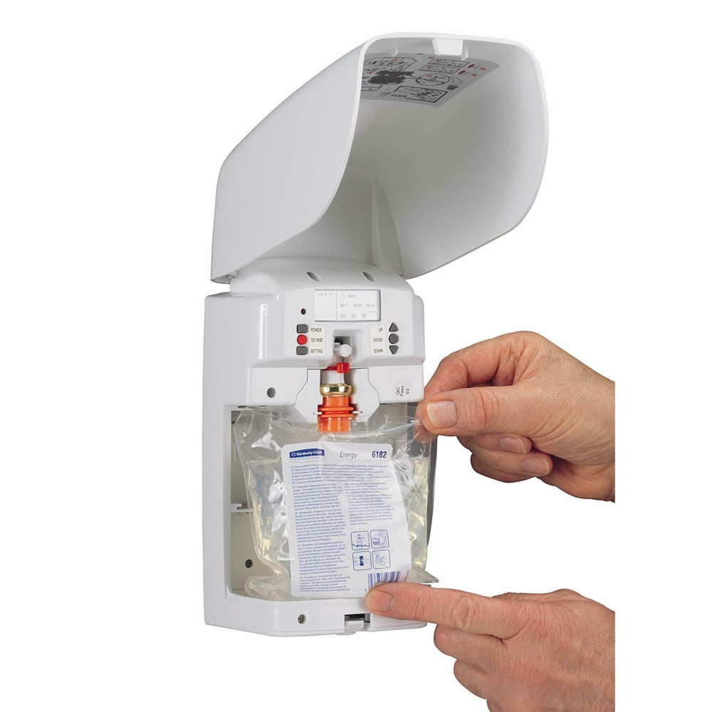 A person inserts a refill bag into the opened Aquarius™ air freshener - White (Kimberly-Clark GmbH), with a white cover and instructions in the lid, ensuring a fresh scent in the room.