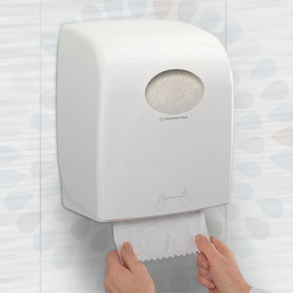 A person pulls a Kleenex® ULTRA™ hand towel roll (White, 150m) from Kimberly-Clark GmbH from a wall dispenser in a toilet, ensuring hygienic hand drying. Packaging: 6 rolls/box.