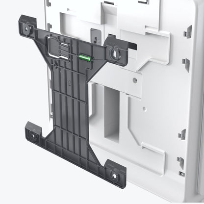 On the back of the Kimberly-Clark Professional™ Icon™ Electronic Hand Towel Dispenser in White, there is a black plastic bracket with an integrated spirit level, detailing the hygienic mounting system.
