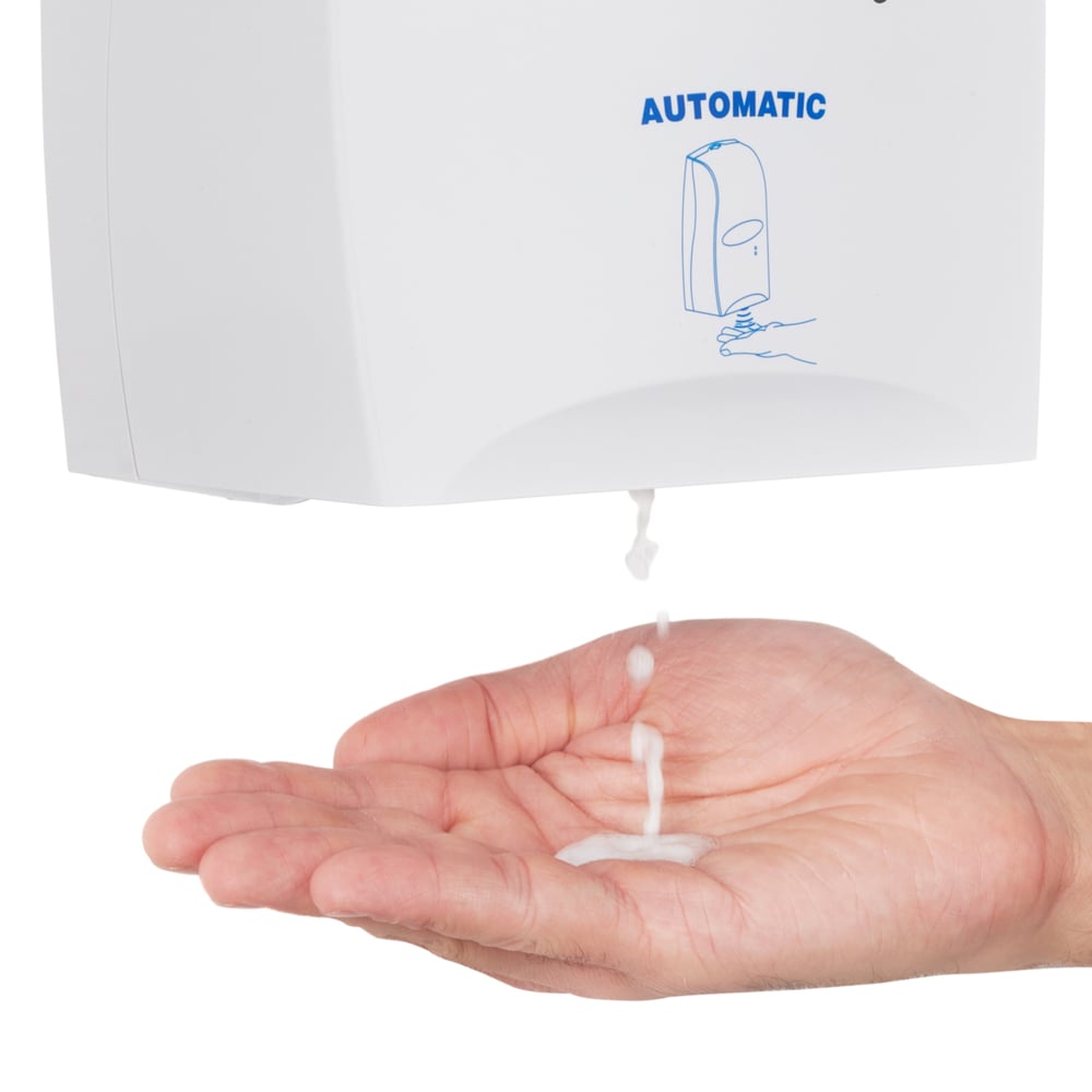 A hand is held under a Scott® CONTROL hand sanitizing foam dispenser from Kimberly-Clark GmbH while alcohol-based foam is dispensed onto the palm. The transparent 1.2-liter cartridge dispenser is labeled "AUTOMATIC" and features a simple blue graphic.