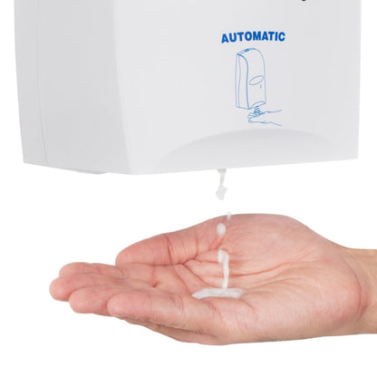 A hand is held under a Scott® CONTROL hand sanitizing foam dispenser from Kimberly-Clark GmbH while alcohol-based foam is dispensed onto the palm. The transparent 1.2-liter cartridge dispenser is labeled "AUTOMATIC" and features a simple blue graphic.