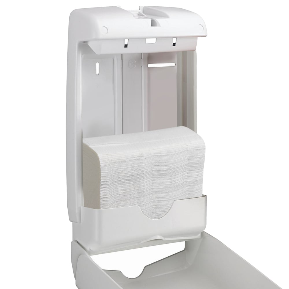 A white plastic wall dispenser is open and shows Scott® SLIMFOLD folded hand towels from Kimberly-Clark GmbH inside. The simple design offers hygienic hand drying with 16 clips x 110 sheets per carton (16 packs).