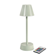 The wireless LED lamp ZELDA in pistachio color (33 cm x 10 cm) by Duni GmbH has a modern conical shade and a cylindrical base; next to it is a rectangular remote control with colorful buttons.