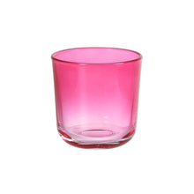 A fuchsia-colored Switch & Shine glass candle holder from Duni GmbH with a round shape and stable base stands on a white background.