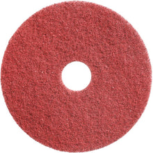 The Twister Pad, scrubbing and deep cleaning pad, red by Diversey Deutschland GmbH & Co. OHG is round, has a textured surface and a hole in the middle, ideal for professional cleaning applications, photographed against a white background.