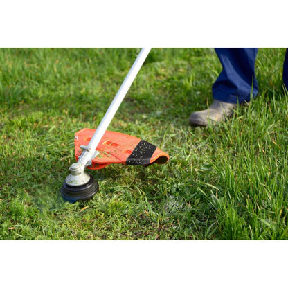 A person in blue pants and boots is trimming uneven green grass outside. Nearby, a roll of Scotch® Extremium™ Ultra High Performance Tape DT17 (25 m x 48 mm, 1 roll) from 3M Deutschland GmbH lies on the ground, ready for strong tape requirements.