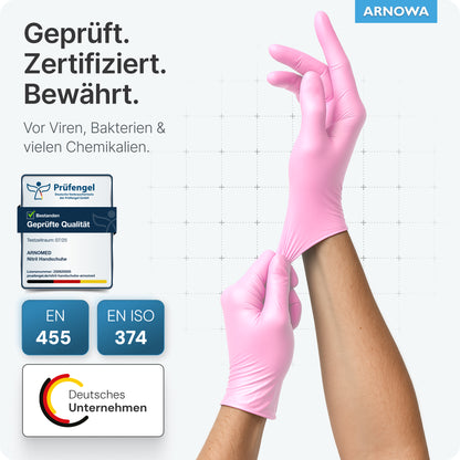 A person is wearing ARNOMED NITRIL BLOSSOM ROSE disposable gloves made of pink nitrile by ARNOWA GmbH, certified as latex-free and protective against viruses, bacteria, and chemicals; the logos EN 455 and EN ISO 374 as well as a German company emblem are shown.