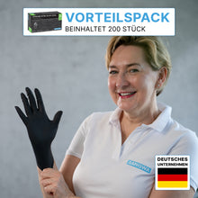 A woman in a white ARNOWA GmbH polo shirt puts on ARNOMED NITRIL BLACK 200-pack black nitrile gloves. Pictured is a box with the inscription "Disposable gloves 200-pack", latex-free, powder-free, with the German flag and "Value pack: 200 pieces".