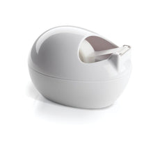 The Scotch™ Karim Rashid tape dispenser from 3M Deutschland GmbH is a white, oval tape dispenser with a tape roll inside, standing on a reflective white surface.