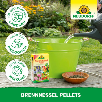 A green bucket and a brown bowl with Neudorff Shop Nettle Pellets stand outdoors. A watering can fills the bucket while a box of these pellets stands next to it - perfect as a plant tonic for your garden.