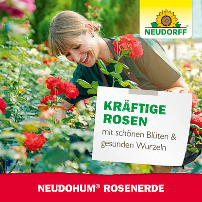 A woman in a green apron smiles while tending blooming red roses in a garden center. The text promotes Neudorff Shop's NeudoHum Rose Soil for strong, healthy rooting roses. The Neudorff logo is visible.
