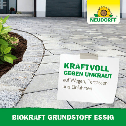 A paved driveway next to a mulched garden bed with green plants. A surface advertises BioKraft Base Material Vinegar from Neudorff Shop for weed-free terraces, paths, and driveways. Text: "POWERFUL AGAINST WEEDS.