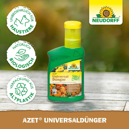 A green bottle of Neudorff Shop Azet Universal Liquid Fertilizer with a yellow cap rests on wood. The label depicts fruits, vegetables, and plants, with symbols for pet safety, organic ingredients, and recycled packaging.