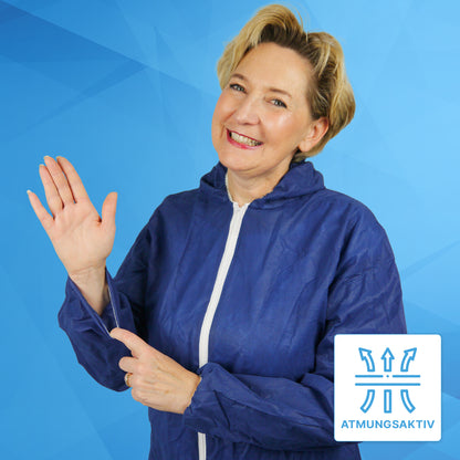 A smiling woman in the ARNOMED COVER PP-OVERALL XTRA STRONG by ARNOWA GmbH, a blue extra strong disposable coverall with a hood, waves and points to her sleeve, while a "Breathable" symbol highlights the breathability.