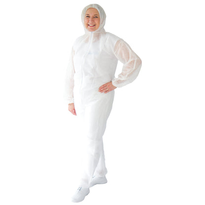 A smiling person stands with one hand on their hip, wearing the white disposable coverall ARNOMED COVER PP-OVERALL XTRA STRONG with a hood from ARNOWA GmbH and white shoes against a white background.