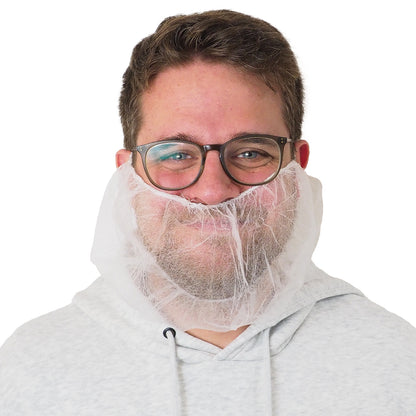A man with glasses and a light gray hoodie is wearing an ARNOMED PP beard protector White, with elastic band, disposable (ARNOWA GmbH) over his mouth and chin. The background is solid white.