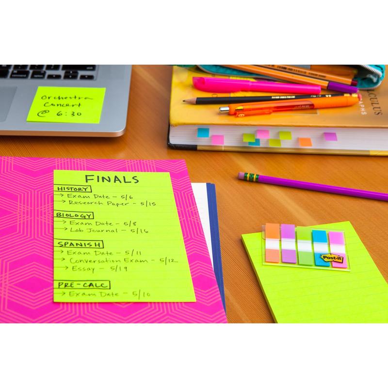 On the desk are colorful school supplies, books, pens, and a folder with a 3M Post-it® Super Sticky Note (lined large format, 101x152mm), displaying the schedule for final exams in history, biology, Spanish, and precalculus.