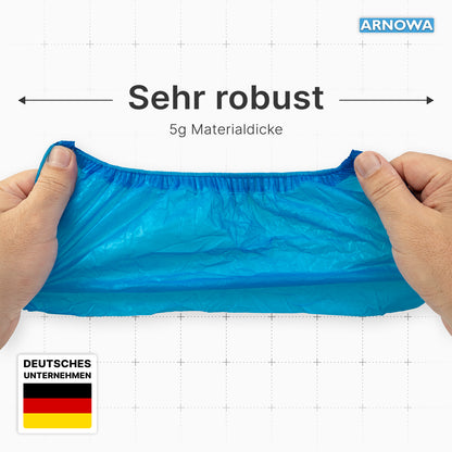 Two hands stretch a bright blue ARNOMED Xtra Strong CPE shoe cover from ARNOWA GmbH. "Very robust" and "5g material thickness" show the strength. Waterproof, disposable, with German flag and "GERMAN COMPANY". Bag of 100 pieces.