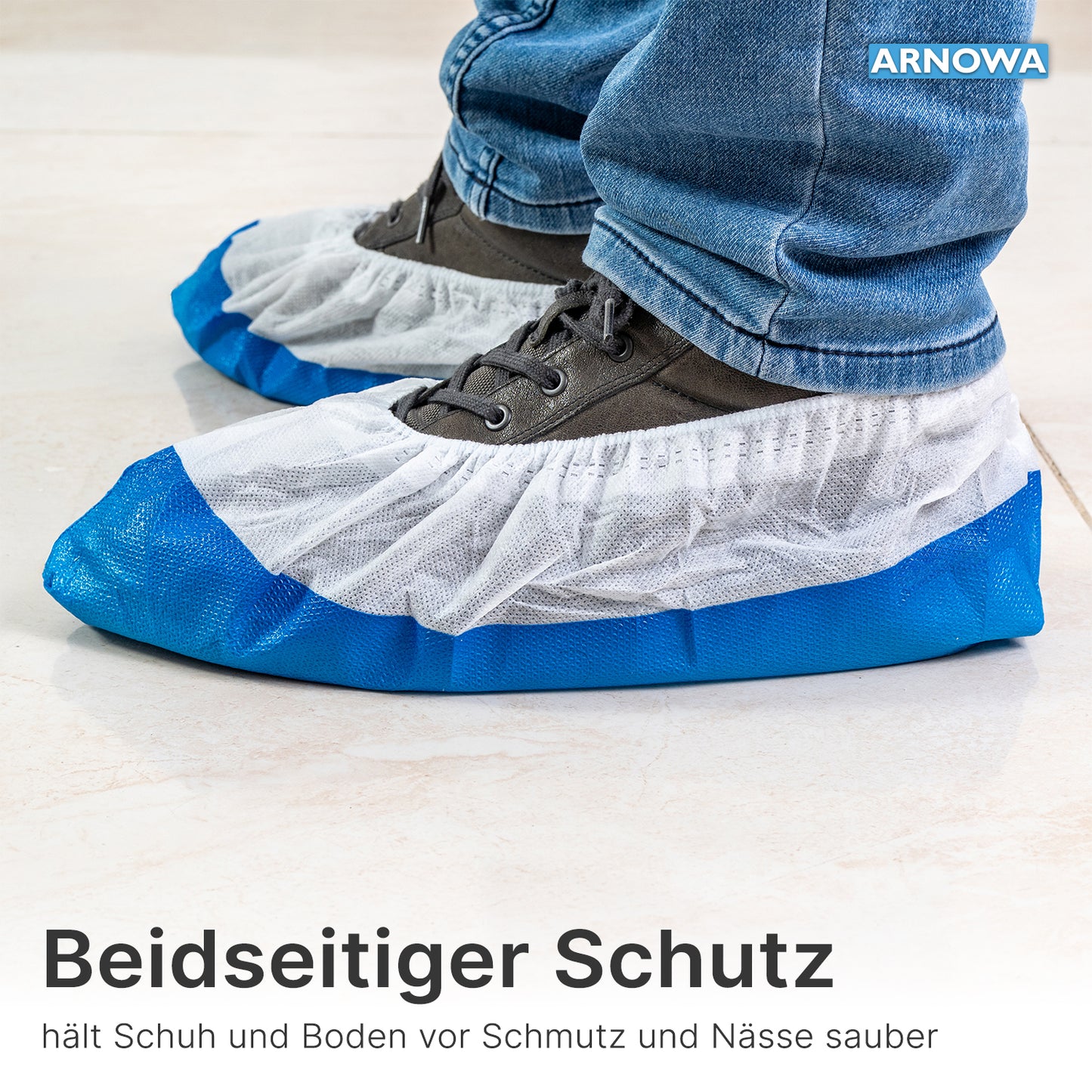 Person wears ARNOMED CPE/PP shoe covers from ARNOWA GmbH, waterproof and in blue-white, over gray shoes on light tiles; text and branding are visible.