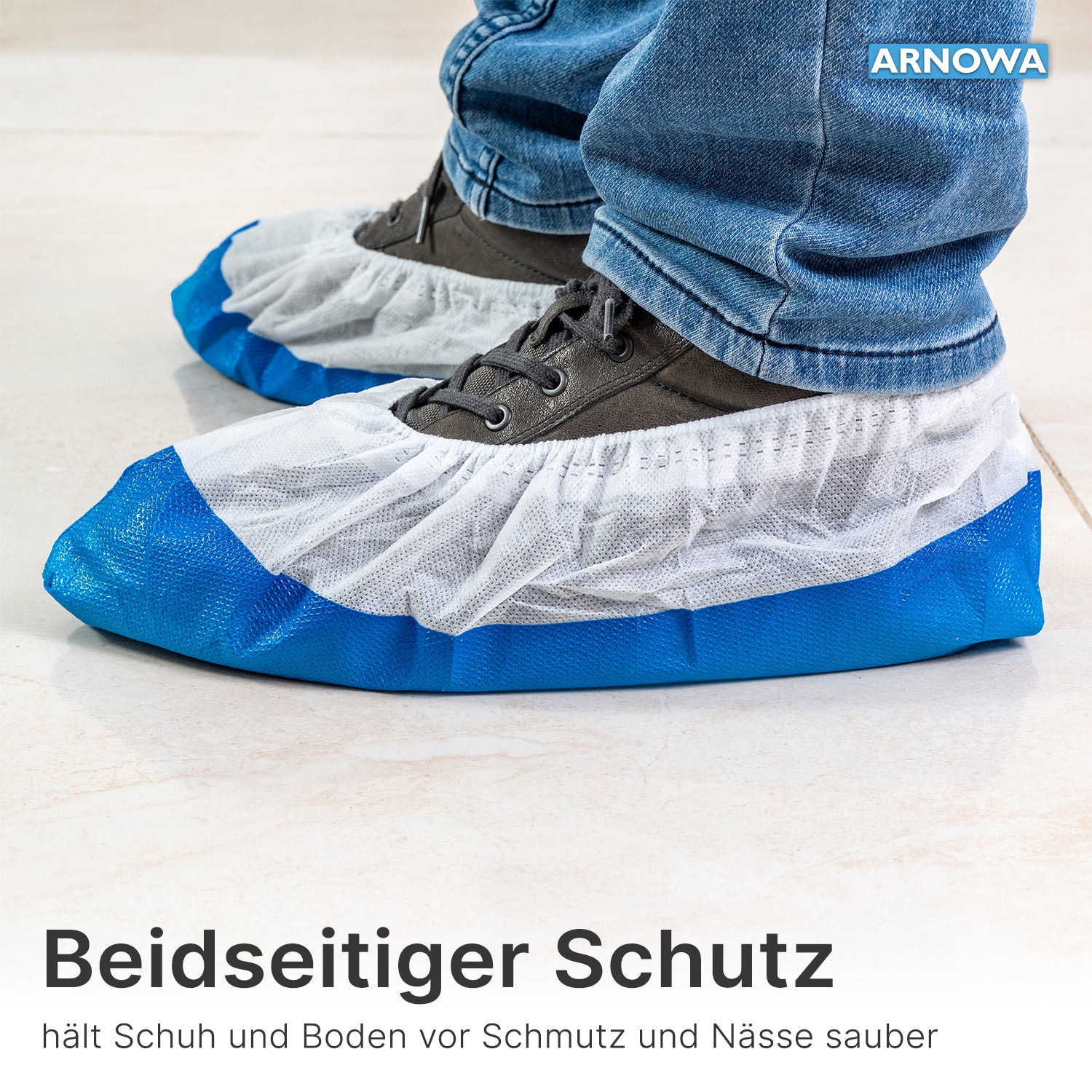 Person wears ARNOMED CPE/PP shoe covers from ARNOWA GmbH, waterproof and in blue-white, over gray shoes on light tiles; text and branding are visible.